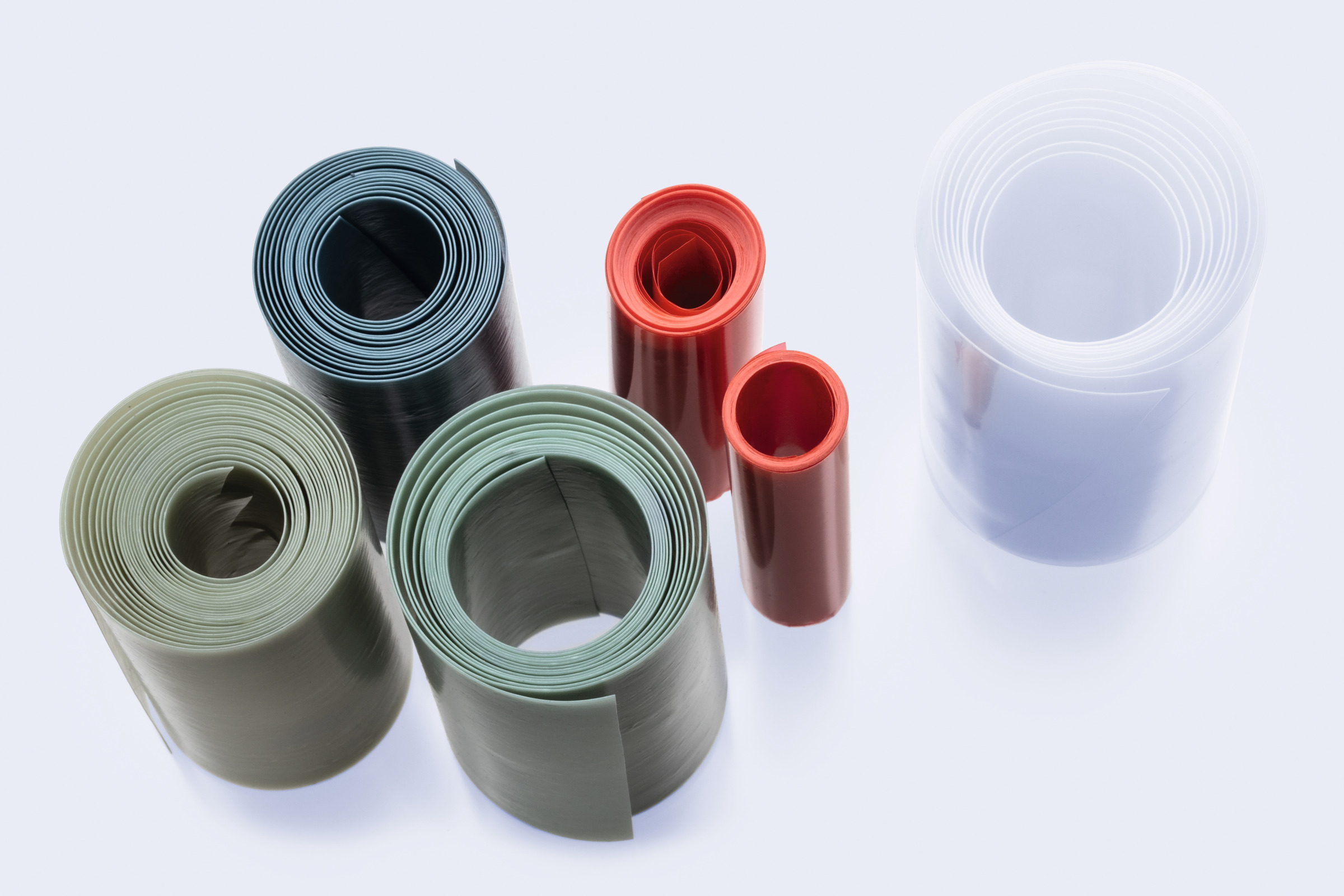 Rolled polymer and plastic film sheets in different colors and thicknesses arranged on a laboratory surface for material testing