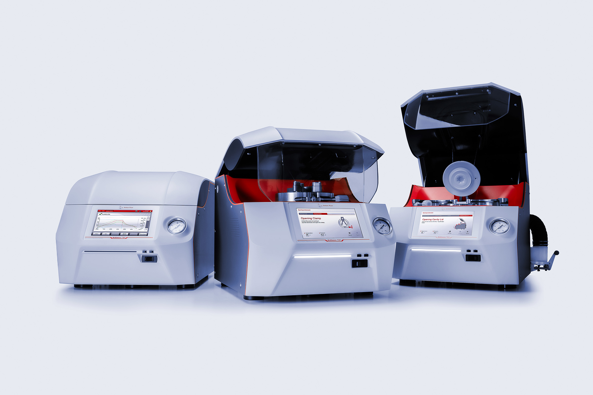 Three Anton Paar Multiwave 7x01 microwave digestion systems, two open showing rotors and cavity lids, on a light studio background