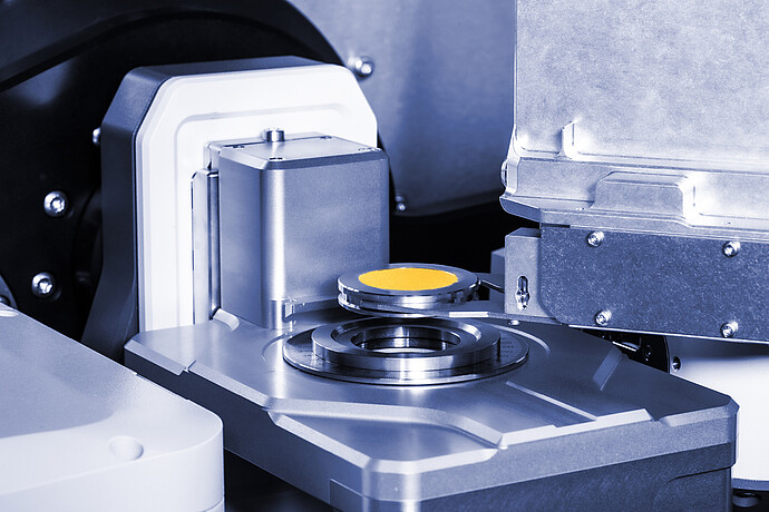 XRDynamicオートサンプラーが提供する、測定ステージの上に配置された黄色い粉末のサンプルホルダー。