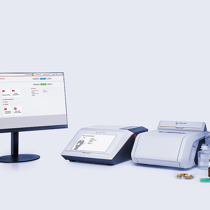 Cora 5001 Raman spectrometer and Lyza 3000 FTIR spectrometer connected to a monitor displaying the Spectroscopy Suite spectral analysis software, with various pharmaceutical samples and containers nearby.