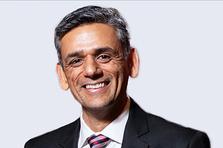 Rishi Kaushik, President & CEO of Anton Paar USA, Inc., wearing a dark suit and red striped tie.