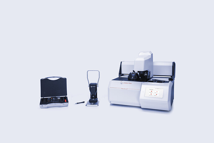 Anton Paar Julia DSC 500 with automated sample changer, manual sample press, and accessory kit with tools arranged on a neutral background