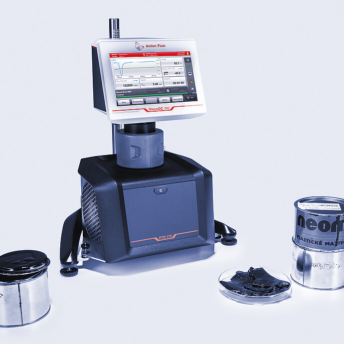 Three-quarter front view of the ViscoQC 300 rotational viscometer with the PTD 175 Peltier temperature device, shown with grease tins and a petri-dish sample on a light blue background