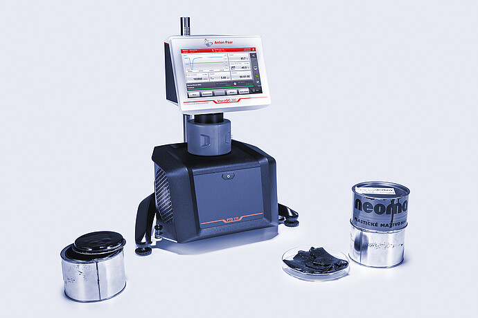 Three-quarter front view of the ViscoQC 300 rotational viscometer with the PTD 175 Peltier temperature device, shown with grease tins and a petri-dish sample on a light blue background