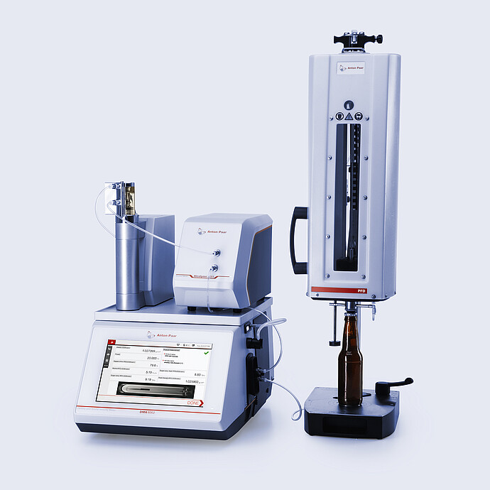 Anton Paar DMA 6002 SV with Alcolyzer 3001 Spirits and CarboQC ME with Option O2, connected to PFD filling device with glass bottle positioned under filling head