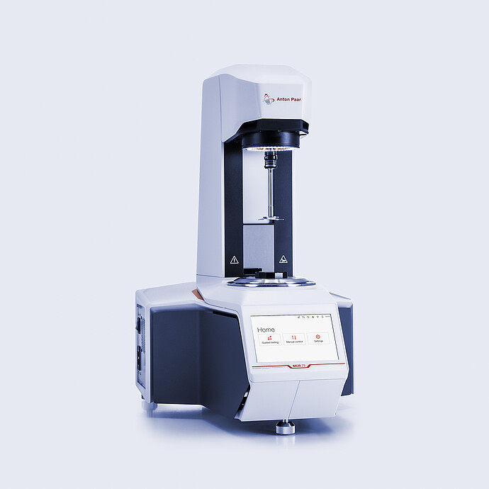 Anton Paar MCR 73 Modular Compact Rheometer in three-quarter view with open measuring area and touchscreen home menu.