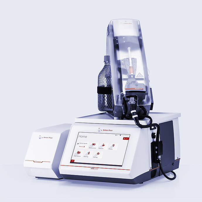 Anton Paar DMA 5002 density meter with Xsample 610 sample changer on top, bottle holder, black tubing, and separate Xsample module