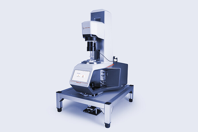 Anton Paar MCR 703 rheometer equipped with the Rheo-Iris optical accessory, mounted on a vibration-damping table with active touchscreen display.