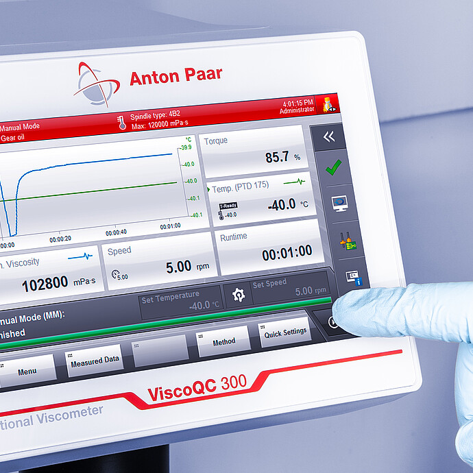 Angled close-up of the ViscoQC 300 touchscreen as a gloved hand taps the interface, showing a gear oil test and PTD 175 temperature at −40.0 °C
