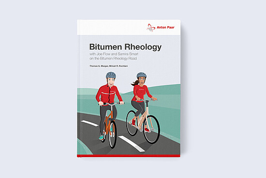 Cover of the Anton Paar book “Bitumen Rheology – with Joe Flow and Samira Smart on the Bitumen Rheology Road” by Thomas G. Mezger and Mrinal R. Rochlani, showing two illustrated cyclists in Anton Paar clothing riding on a road.