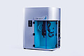 High-pressure volumetric gas sorption analyzer iSorb HP2 by Anton Paar, featuring a sleek silver design with a transparent blue-front chamber, internal tubing, and precision components visible inside. The device includes control panels and ports for gas adsorption measurements, designed for high-pressure gas storage and separation analysis.