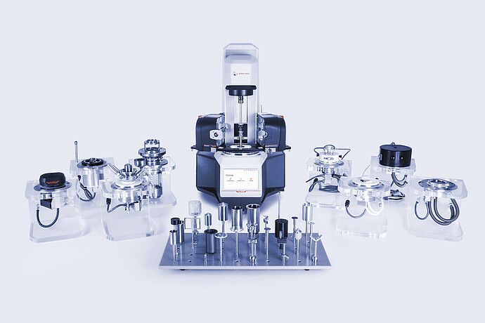 Anton Paar Modular Compact Rheometer MCR with accessory modules and measuring geometries arranged on a studio surface