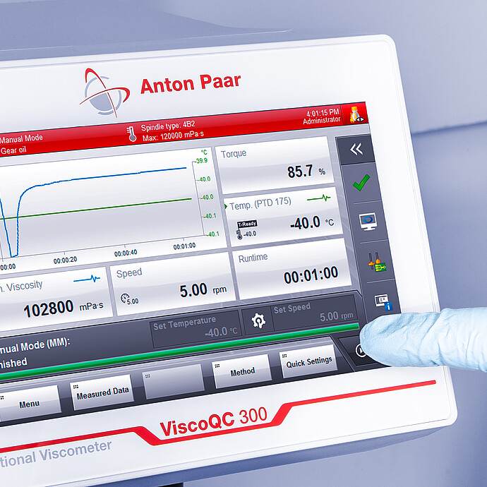 Angled close-up of the ViscoQC 300 touchscreen as a gloved finger taps Start, showing a gear oil test with spindle type 4B2 and PTD 175 temperature at −40.0 °C on a light blue background