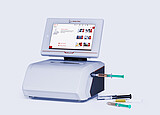 Anton Paar Lyza 7000 FTIR spectrometer with touchscreen, connected flow cell, and several syringes on a light gray background.
