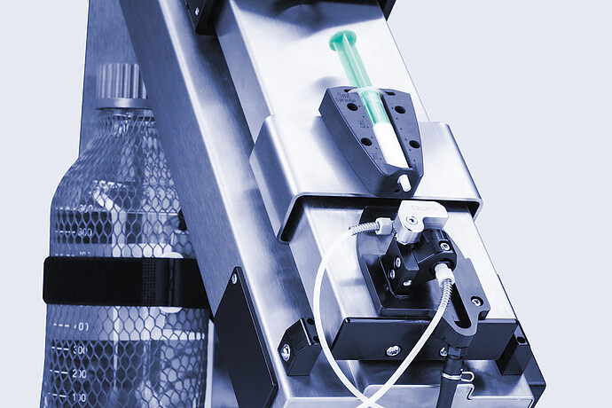 Anton Paar Xsample 340 sample changer with 5 mL syringe, cleaner port, tubing, and bottle held in side bracket