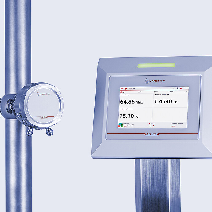 L-Rix inline refractometer mounted on a stainless steel pipe, connected to the Edge 7000 evaluation unit displaying real-time Brix, refractive index, and temperature measurements on its touchscreen interface.