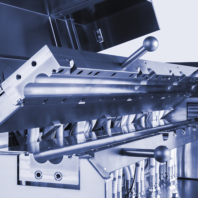 Close-up of Brabender TwinLab B-TSE-S-30-40 twin-screw extruder process section with opened barrel, clamps, and connected piping