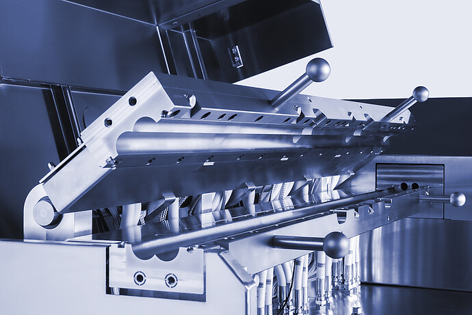 Close-up of Brabender TwinLab B-TSE-S-30-40 twin-screw extruder process section with opened barrel, clamps, and connected piping