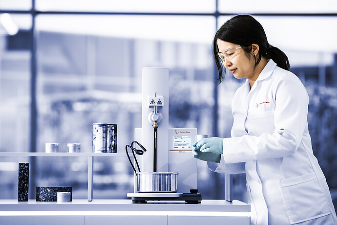 Technician operating Anton Paar Penetrometer PNR 500 in a laboratory, preparing metal sample cup for penetration measurement.