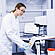 Lab technician in safety glasses operating an Anton Paar Modular Compact Rheometer MCR on a laboratory bench