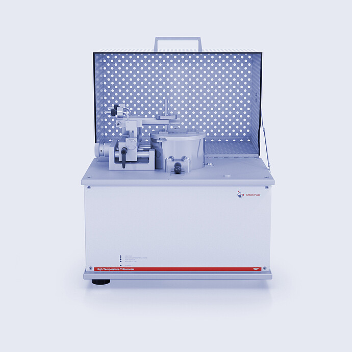 Anton Paar High Temperature Tribometer THT with open protective cover and pin-on-disk test setup on a white background