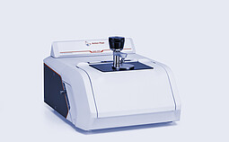 Anton Paar Lyza 3000 FTIR spectrometer with a sample holder centered on its measurement area against a light gray background.