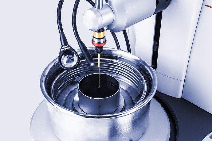 Close-up of Anton Paar Penetrometer PNR 500 with needle probe above sample in test vessel, illuminated by external light guides.