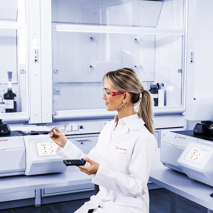 Technician handling sample tray beside Anton Paar Julia DSC 300 and second Julia DSC instrument, with Julia Suite displayed on monitor in laboratory setting