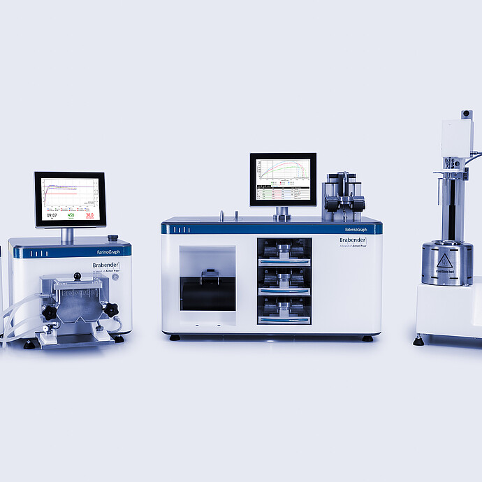 Brabender FarinoGraph, ExtensoGraph, and Amylograph-E arranged side by side with monitors, showing dough mixing, stretching, and viscosity analysis instruments in a lab setup