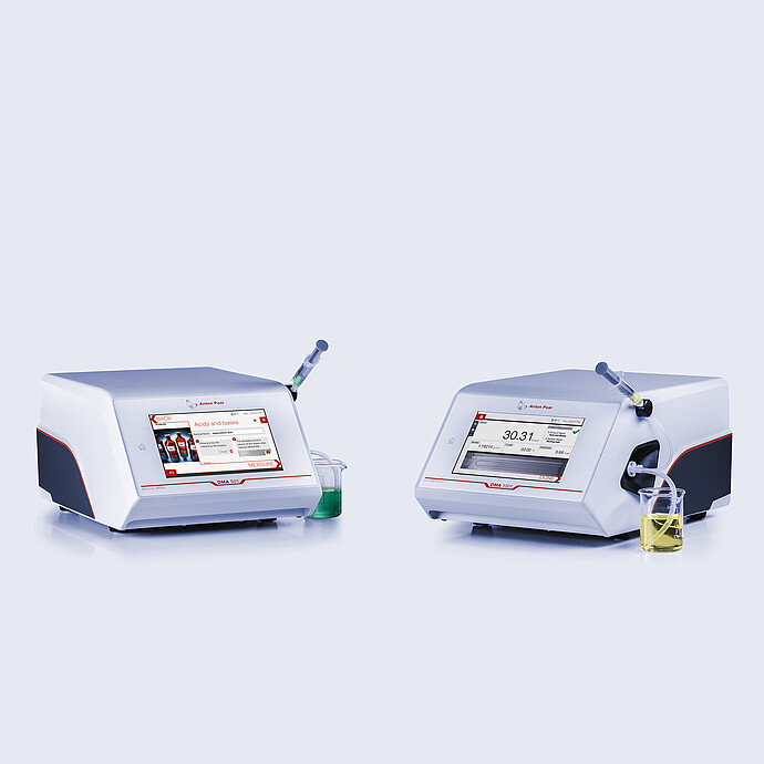 Anton Paar DMA 501 and DMA 1001 density meters side by side, each with a syringe and sample beaker, displaying measurement interfaces.