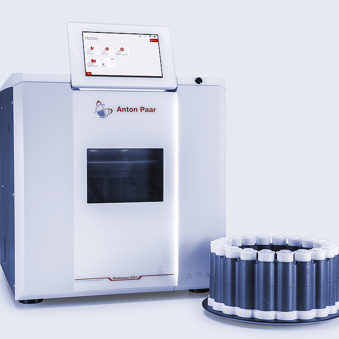 Multiwave 5001 microwave digestion system beside a rack with white-capped microwave digestion vessels.