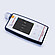 Anton Paar Cora 101 handheld Raman spectrometer lying on a flat surface with its display showing scan menu options.