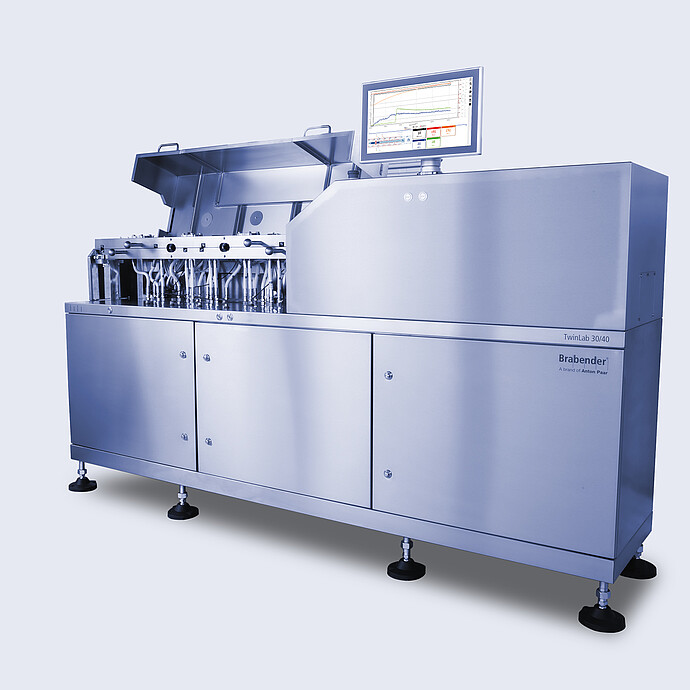 Angled view of Brabender TwinLab B-TSE-S-30-40 twin-screw extruder with open process section, visible piping, and mounted touchscreen