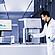 Lab technician loading a sample into the Anton Paar Autosorb 3300, with measurement graphs shown on a monitor