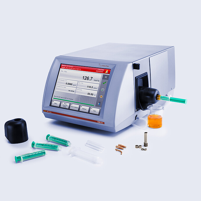 Anton Paar SVM 3001 rotational viscometer with Hot Filling Attachment mounted on the filling port, shown with syringes, filling accessories, and a beaker containing heated high-viscosity sample.