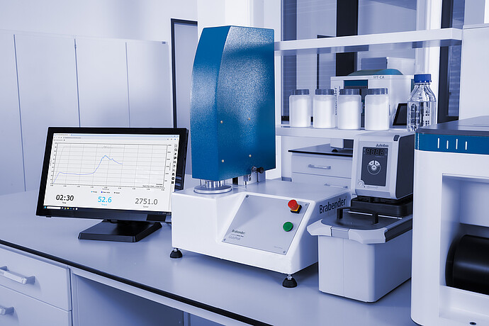 Brabender GlutoPeak analyzer with Julabo temperature control unit and data display on monitor, set up in a laboratory environment.