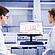 Two laboratory technicians working with an Lyza 3000 FTIR spectrometer placed on the bench in front of a central monitor displaying the Spectroscopy Suite spectral analysis software