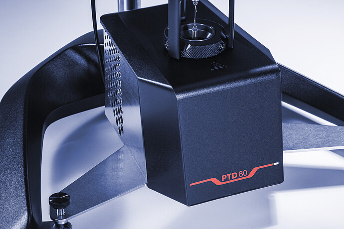 Close-up angled view of the PTD 80 Peltier temperature device, showing the temperature chamber opening and vented housing mounted on the ViscoQC viscometer base