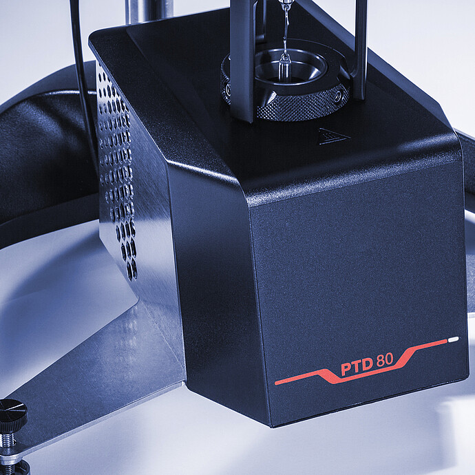 Close-up angled view of the PTD 80 Peltier temperature device, showing the temperature chamber opening and vented housing mounted on the ViscoQC viscometer base