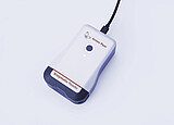 Anton Paar Enzymatic Reader digital ethanol meter with illuminated button and USB cable on light gray background.