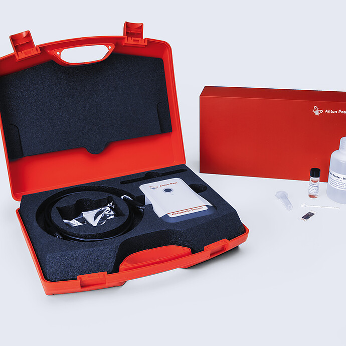 Anton Paar Enzymatic Reader digital ethanol meter kit in red carrying case with test strip, buffer bottle, and accessories.