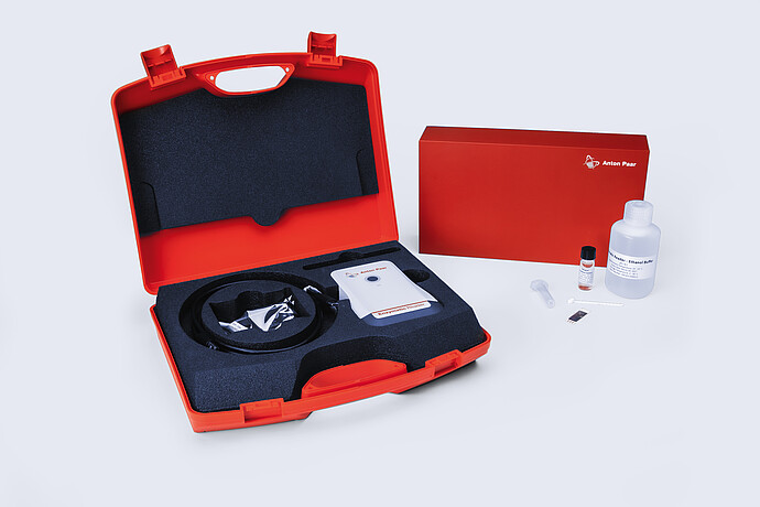 Anton Paar Enzymatic Reader digital ethanol meter kit in red carrying case with test strip, buffer bottle, and accessories.