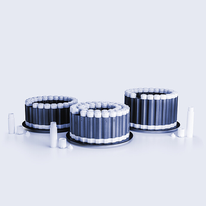 HVT Rotor sets with multiple sealed sample vessels arranged in circular holders, with additional caps and vessels placed on a light background