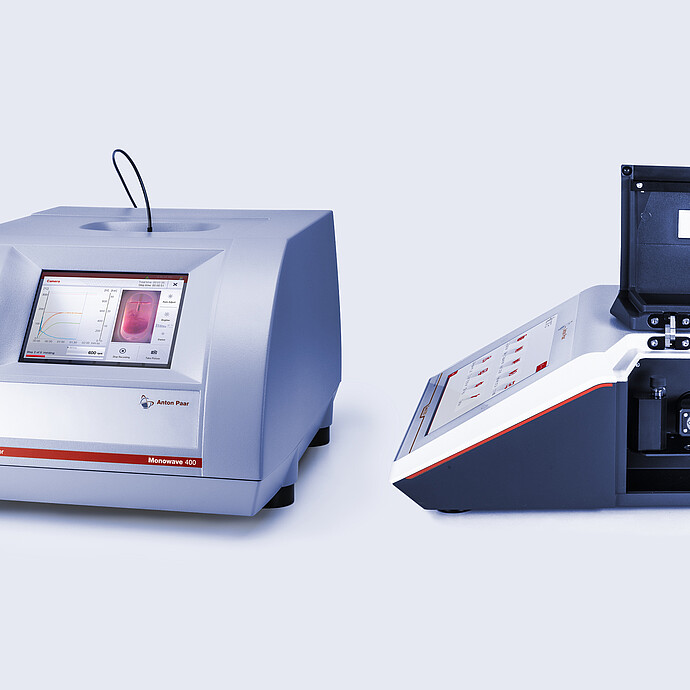 Anton Paar Monowave 400 R microwave synthesis reactor (left) and Cora 5001 Raman spectrometer (right) with an open sample compartment. The Monowave 400 R displays reaction monitoring data on its touchscreen, while the Cora 5001 enables real-time molecular spectroscopy analysis.