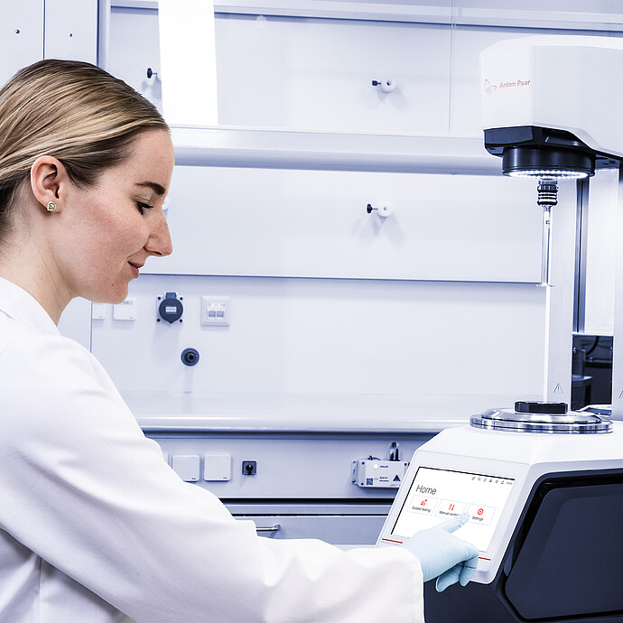 Technician uses the touchscreen on an Anton Paar Modular Compact Rheometer MCR in a laboratory