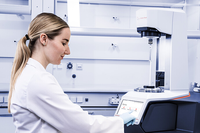 Technician uses the touchscreen on an Anton Paar Modular Compact Rheometer MCR in a laboratory