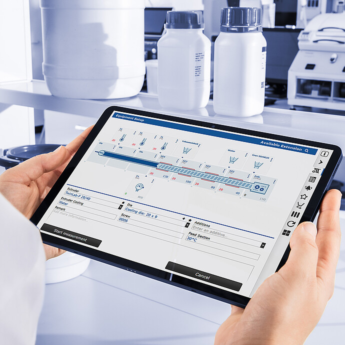 Technician holding tablet displaying Brabender TwinLab B-TSE-S-30-40 control interface, with laboratory containers and equipment in background