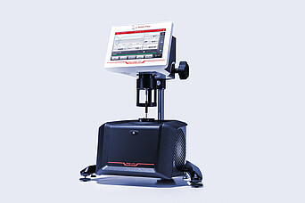 Wide lab view showing a technician preparing a sample at a ViscoQC 300 rotational viscometer with the PTD 175 Peltier temperature device, while another technician works at a ViscoQC 100 viscometer in the background