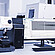 Anton Paar Revetest® Scratch Tester RST 100 setup on a laboratory desk, connected to a computer displaying scratch test results and analysis software on the monitor.
